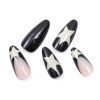 Close-up of five pieces from a set of almond-shaped press-on nails, black and light pink mix, featuring star painting on a French tip.