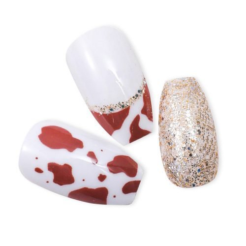 Close-up of three pieces from a 24-piece set of white, gold, and wine red cow pattern press-on nails with golden glitter.