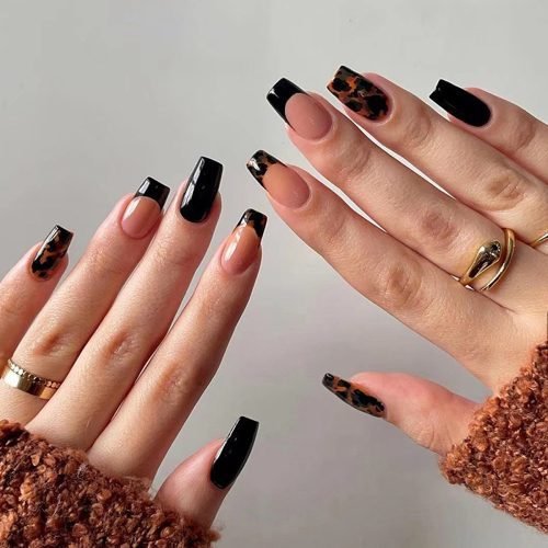 Two hands modeling a set of square press-on nails in pink mixed with black, featuring leopard print and French tips.