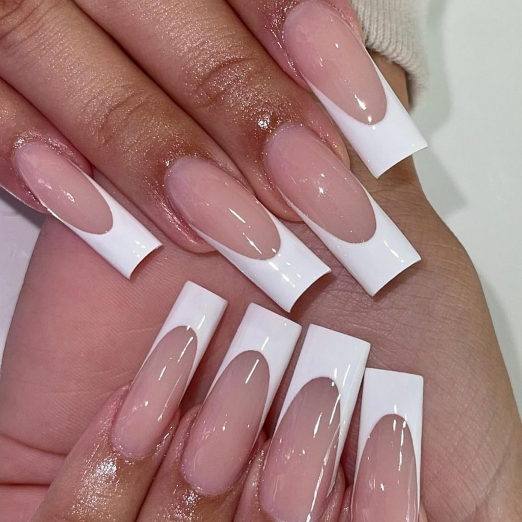 Two hands adorned with a set of square press-on nails in pink, featuring white French tips.