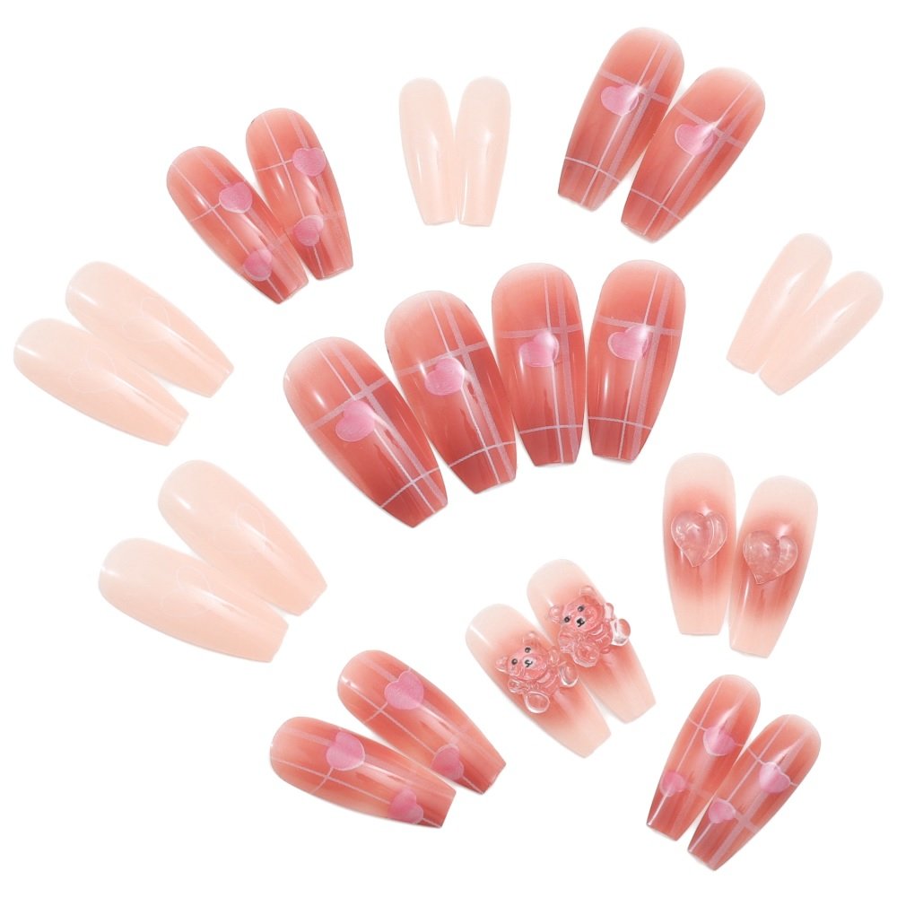 Set of 24 coffin press-on nails in ombre red with heart designs and nude with gel bear embellishments.