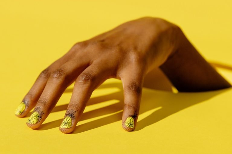 A hand showcasing vibrant yellow press-on nails.